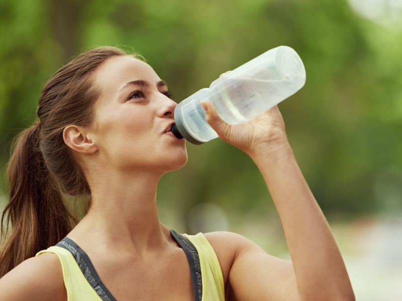 female athlete drinking froma water bottle