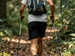 A man running along a trail with walking poles